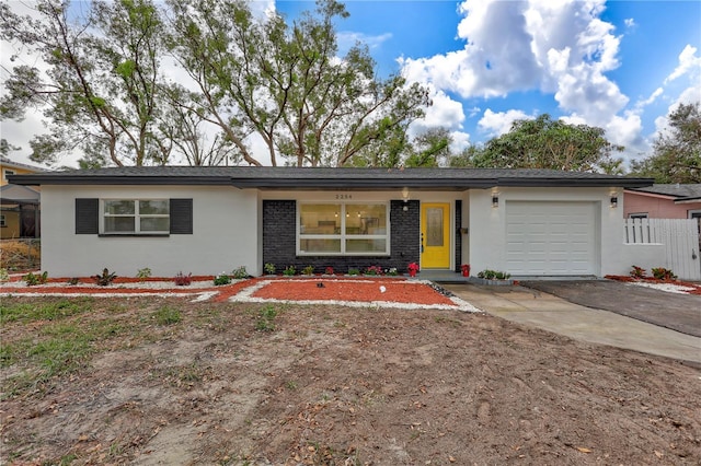 single story home with an attached garage, fence, aphalt driveway, and stucco siding