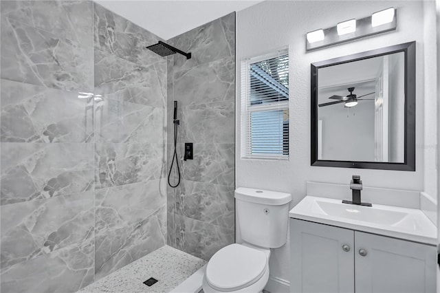 bathroom featuring ceiling fan, toilet, tiled shower, and vanity