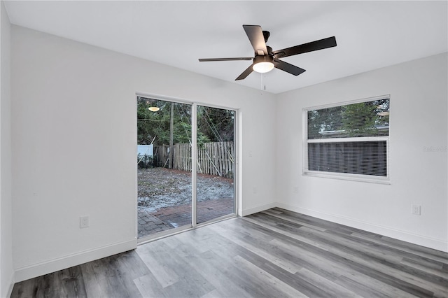 spare room with ceiling fan, plenty of natural light, and hardwood / wood-style floors