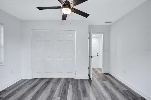 unfurnished bedroom featuring ceiling fan, wood-type flooring, and a closet