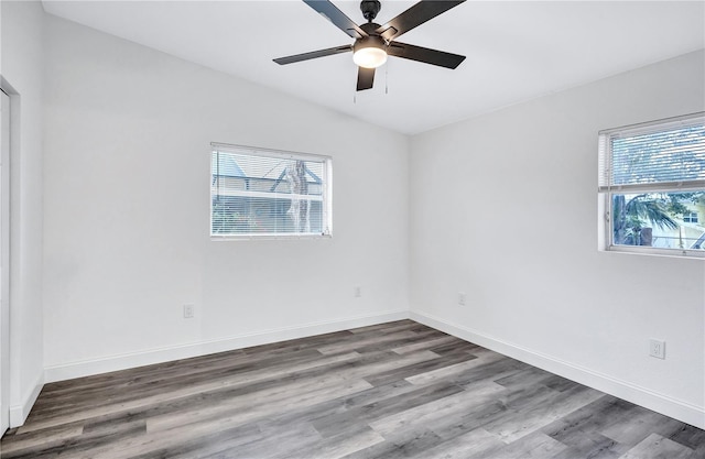 spare room with hardwood / wood-style flooring, vaulted ceiling, and ceiling fan