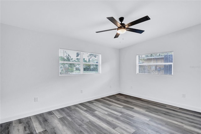 unfurnished room featuring hardwood / wood-style flooring, plenty of natural light, and vaulted ceiling