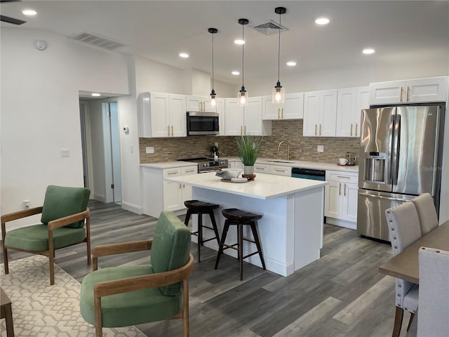 kitchen featuring stainless steel appliances, a center island, visible vents, and white cabinetry