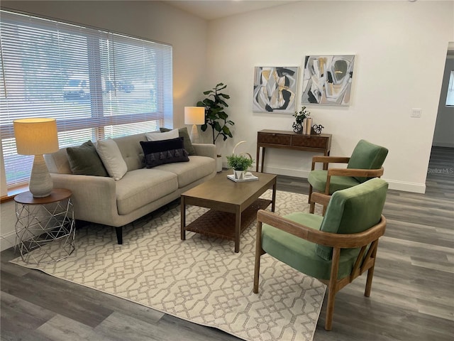 living area with baseboards and wood finished floors