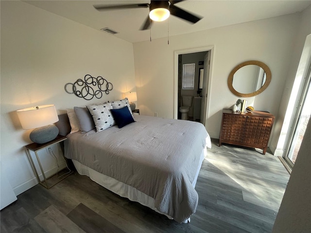 bedroom featuring baseboards, visible vents, ensuite bath, ceiling fan, and wood finished floors