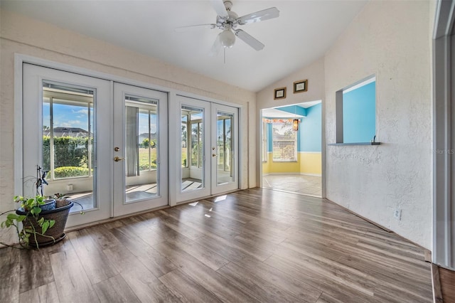 doorway featuring lofted ceiling, ceiling fan, wood-type flooring, and french doors