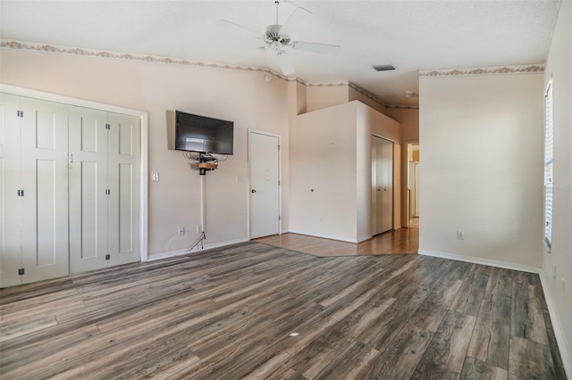 unfurnished bedroom featuring vaulted ceiling, ceiling fan, a textured ceiling, and dark hardwood / wood-style floors