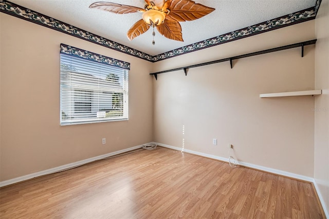 spare room featuring a textured ceiling, light wood-type flooring, and ceiling fan