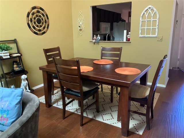 dining room featuring dark wood-type flooring and sink