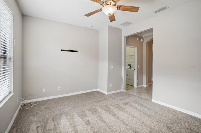 carpeted empty room featuring washer / clothes dryer and ceiling fan