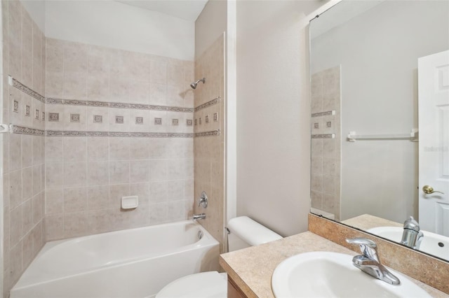 full bathroom featuring vanity, tiled shower / bath combo, and toilet