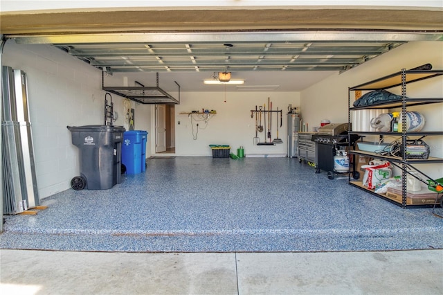 garage featuring electric water heater and a garage door opener