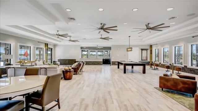 game room featuring light wood-type flooring, a raised ceiling, and pool table