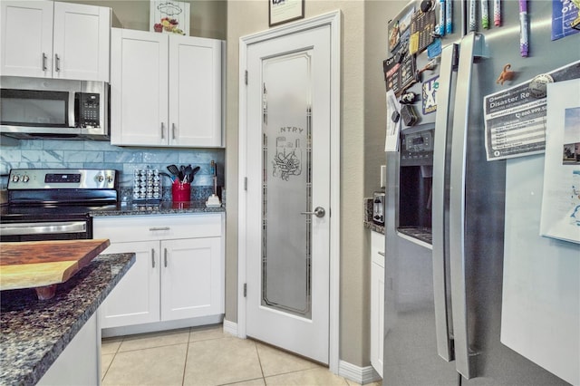 kitchen with decorative backsplash, white cabinets, dark stone counters, and appliances with stainless steel finishes