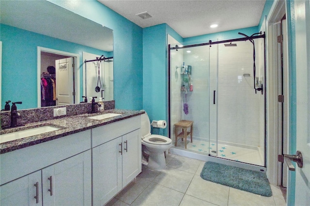 bathroom with tile patterned flooring, vanity, toilet, and an enclosed shower