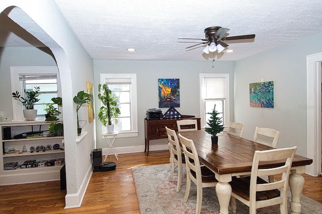 dining space with hardwood / wood-style floors, plenty of natural light, ceiling fan, and a textured ceiling