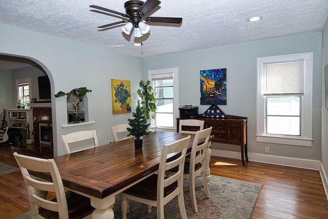 dining space with hardwood / wood-style floors, a textured ceiling, and a wealth of natural light