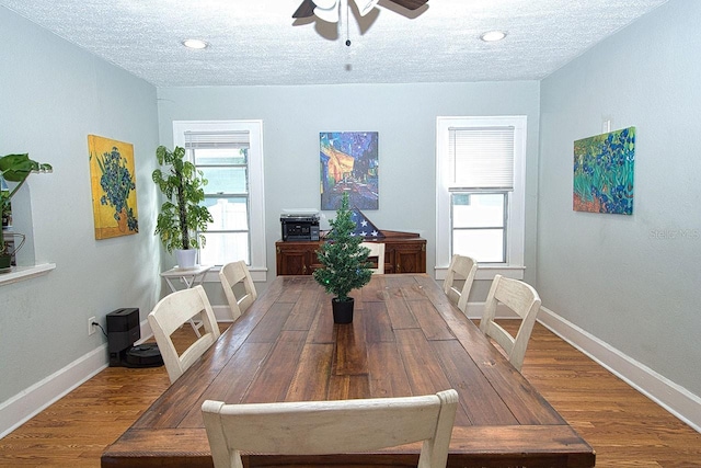 dining area with ceiling fan, a textured ceiling, and hardwood / wood-style flooring