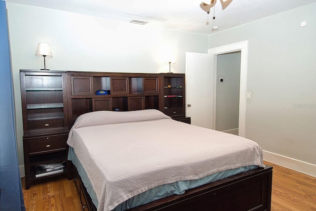 bedroom with ceiling fan and hardwood / wood-style flooring