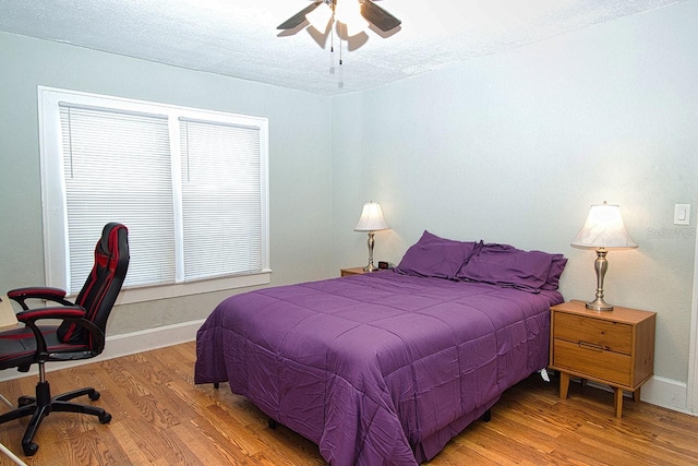 bedroom featuring hardwood / wood-style floors, ceiling fan, and a textured ceiling