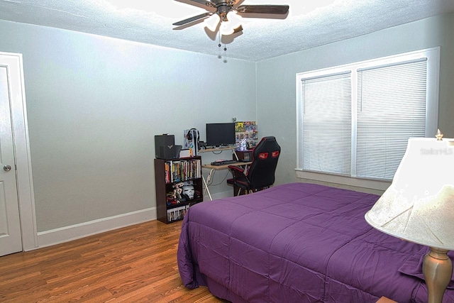 bedroom with hardwood / wood-style floors, a textured ceiling, and ceiling fan