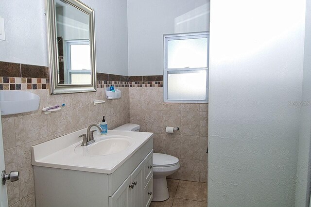 bathroom featuring a wealth of natural light, vanity, and tile walls