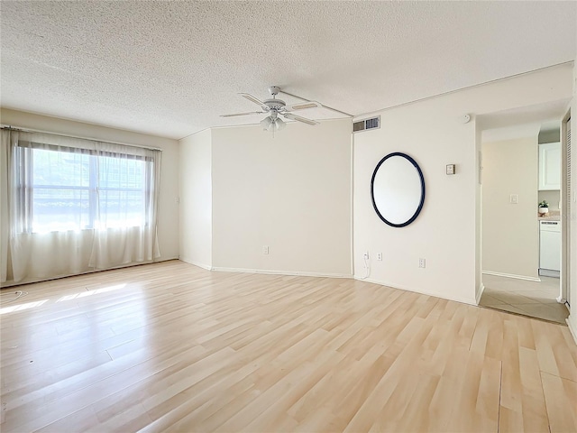 spare room featuring a textured ceiling, light hardwood / wood-style floors, and ceiling fan