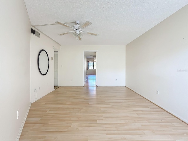 unfurnished room with ceiling fan, light hardwood / wood-style floors, and a textured ceiling