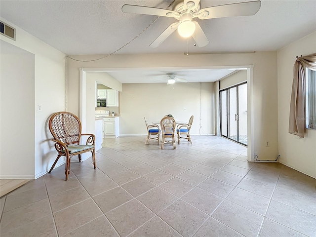 unfurnished dining area featuring ceiling fan and light tile patterned floors