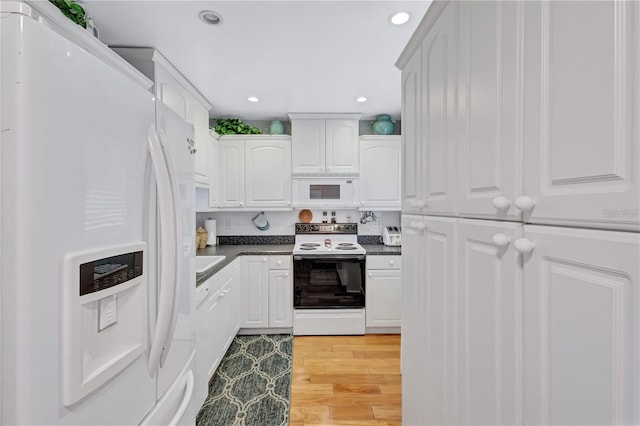 kitchen featuring white cabinets, light hardwood / wood-style floors, and white appliances