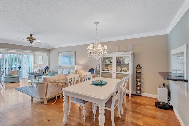 dining area with ceiling fan with notable chandelier, a textured ceiling, light hardwood / wood-style flooring, and ornamental molding