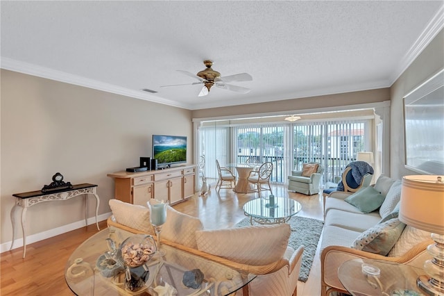 living room with ceiling fan, crown molding, light wood-type flooring, and a textured ceiling