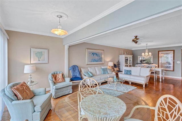 living room featuring hardwood / wood-style floors, ceiling fan with notable chandelier, and crown molding