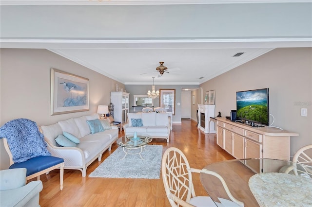 living room with ceiling fan, light hardwood / wood-style floors, crown molding, and a fireplace