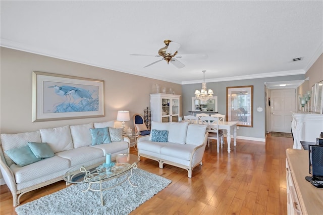 living room with ceiling fan with notable chandelier, light wood-type flooring, and ornamental molding