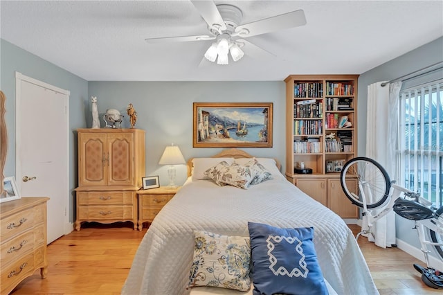 bedroom with ceiling fan and light hardwood / wood-style flooring