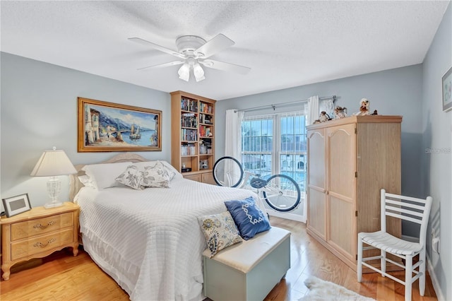 bedroom featuring ceiling fan, a textured ceiling, and light hardwood / wood-style flooring