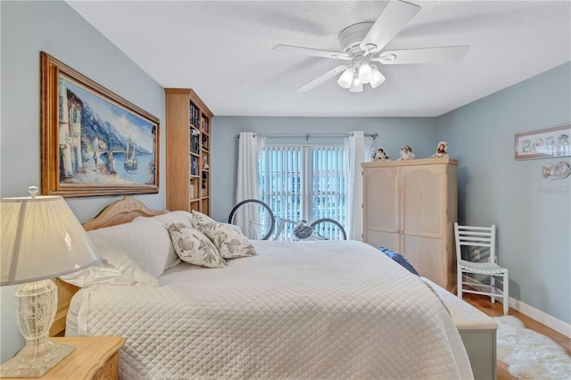 bedroom featuring ceiling fan, light hardwood / wood-style flooring, and a textured ceiling