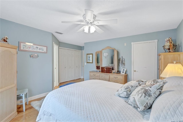 bedroom featuring ceiling fan, light wood-type flooring, and a closet