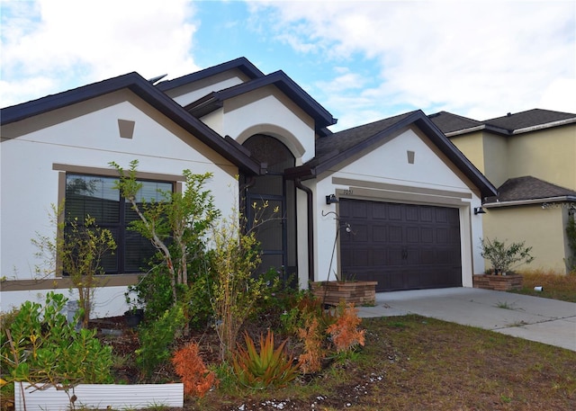 view of front of property featuring a garage, driveway, and stucco siding