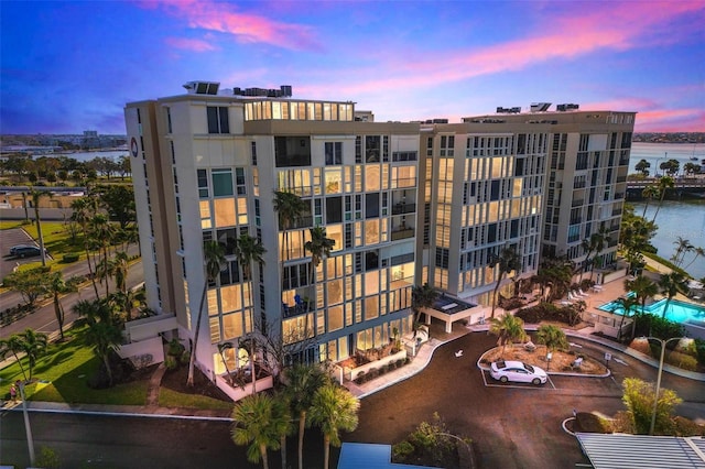 property at dusk with a water view