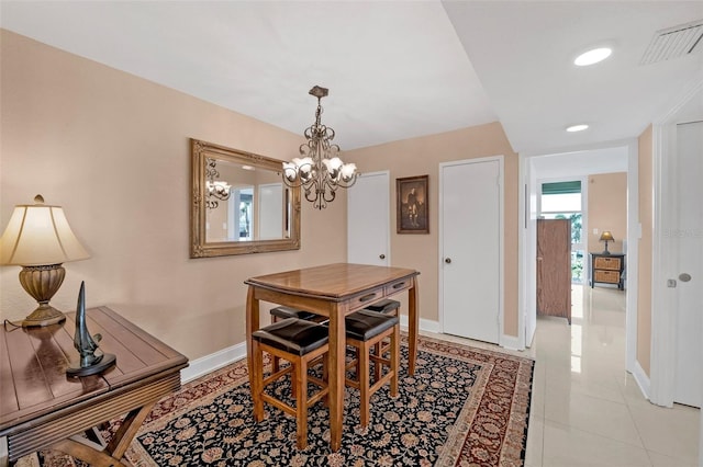 dining space with light tile patterned floors and an inviting chandelier