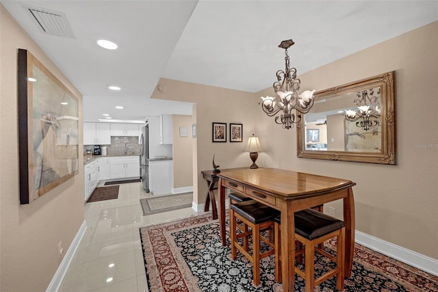 dining room with light tile patterned floors and a notable chandelier