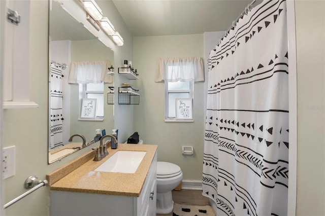 bathroom featuring a shower with shower curtain, vanity, and toilet