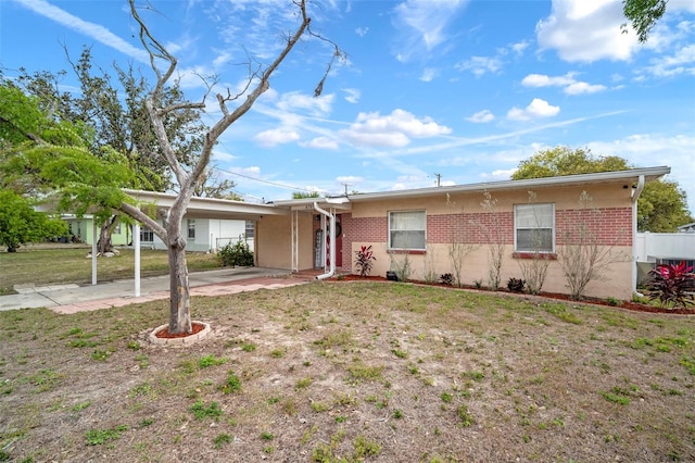 ranch-style home with a carport, a front yard, and brick siding