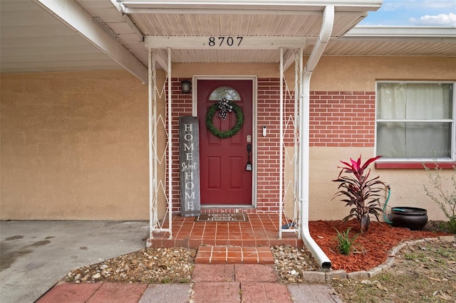 entrance to property with brick siding and stucco siding