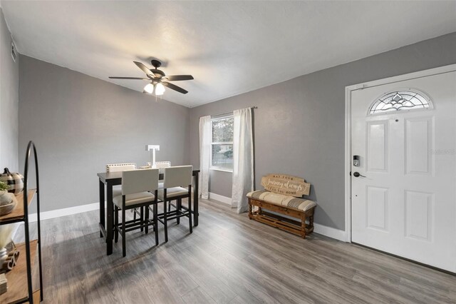 dining area with visible vents, wood finished floors, a ceiling fan, and baseboards