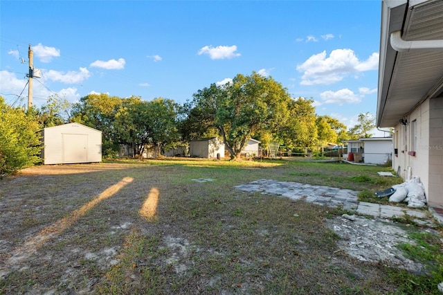 view of yard with an outdoor structure, a storage shed, and fence