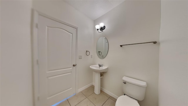 bathroom with tile patterned flooring, vaulted ceiling, and toilet