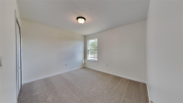 unfurnished room featuring carpet and a textured ceiling